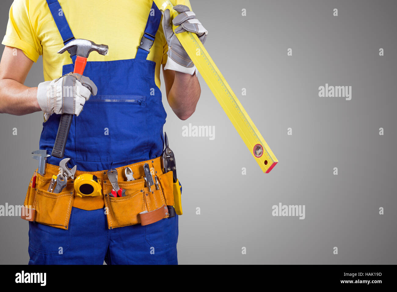 Bauarbeiter mit Werkzeuggürtel in grau mit Textfreiraum Stockfoto