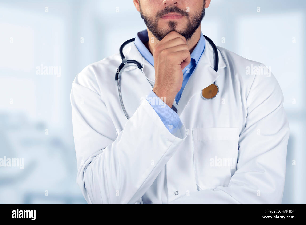 Arzt stehend mit Hand am Kinn Stockfoto