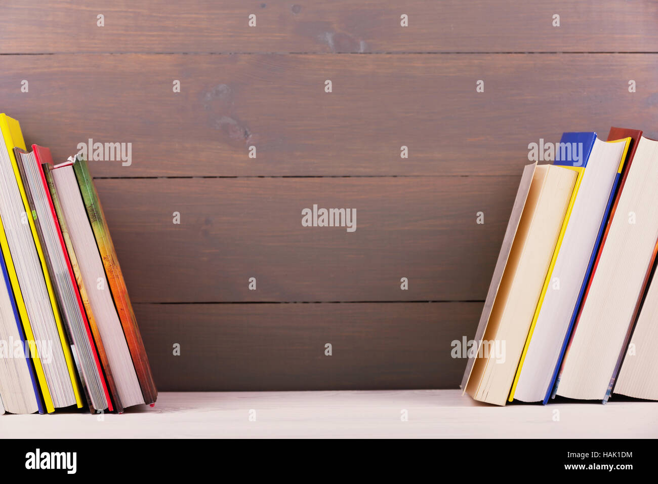 Bücherregal mit Büchern auf Holzbrett Wand Stockfoto