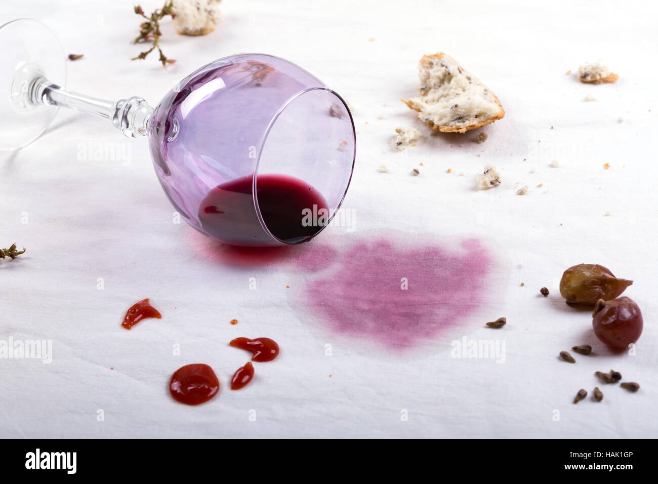 Flecken auf Tischdecke verschüttetes Glas Wein und Essen Stockfoto