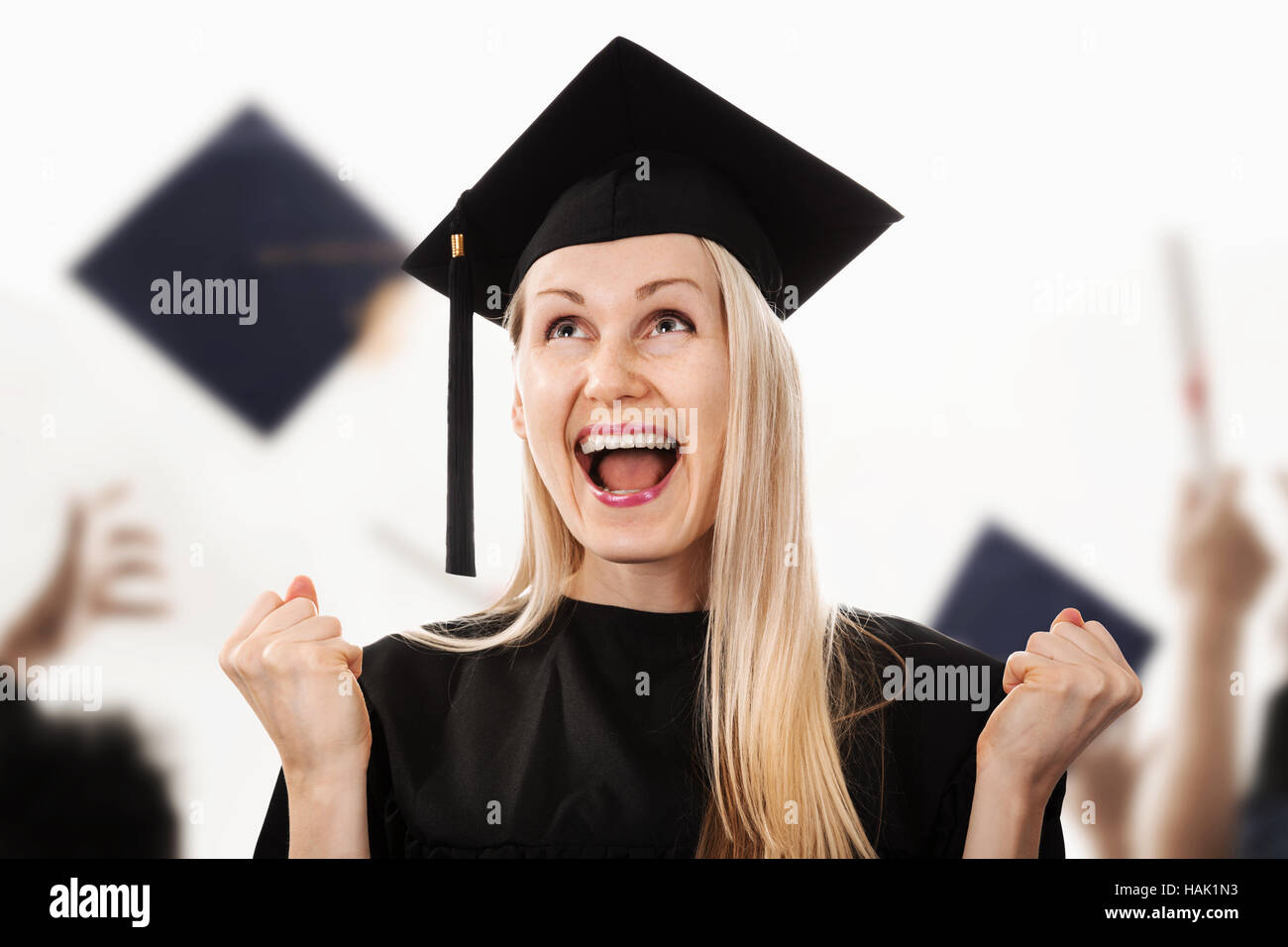 Junge glücklich Hochschulabsolvent tragen Mütze und Mantel Stockfoto