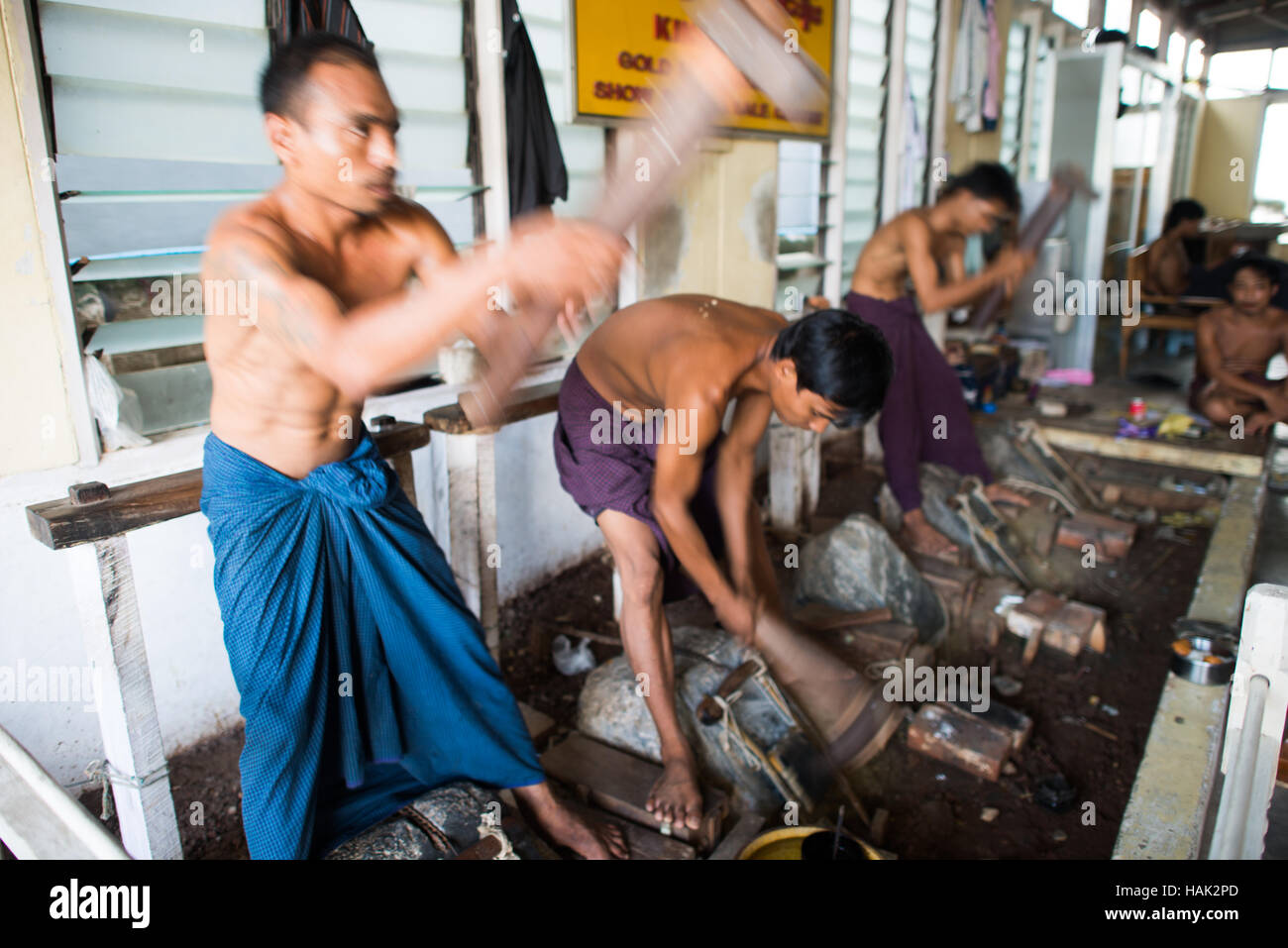 Mandalay Myanmar // MANDALAY, Myanmar - das manuelle Verfahren zum Stampfen und Verpacken von ultradünnen Blattgold, das als religiöse Tribut an Tempeln und Pagoden verwendet wird. Hinweis: Bilder haben Bewegungsunschärfe. Stockfoto