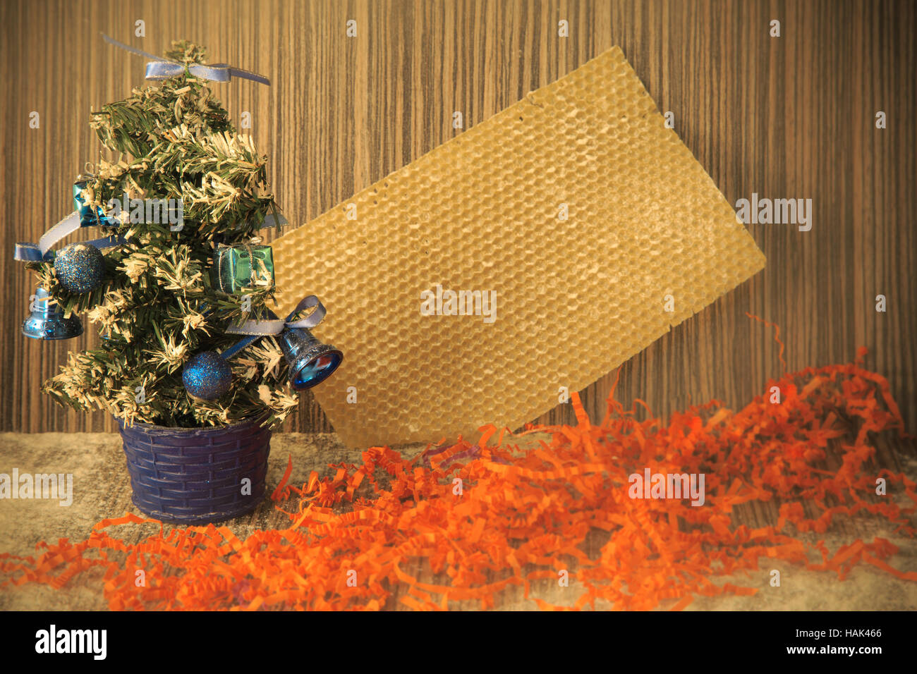 kleinen künstlichen Weihnachtsbaum mit Spielzeugen und Bögen auf hölzernen Hintergrund für Postkarten und Grüße zu Weihnachten und Neujahr Stockfoto