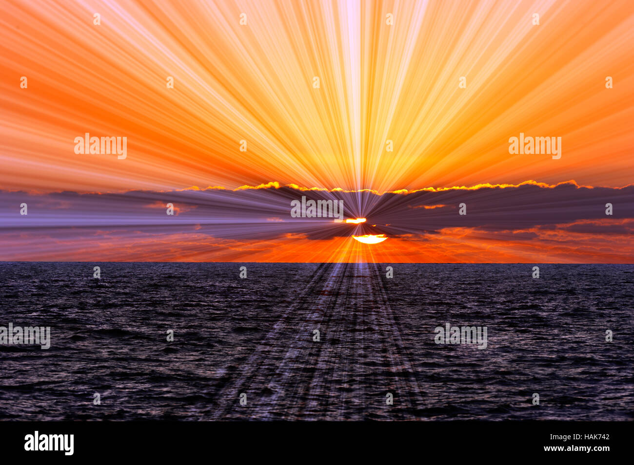 Meer Sonnenuntergang Sonnenstrahlen ist eine Sonne Platzen der Sonnenstrahlen hinter den bunten Wolke gefüllt Himmel heraus fließt. Stockfoto