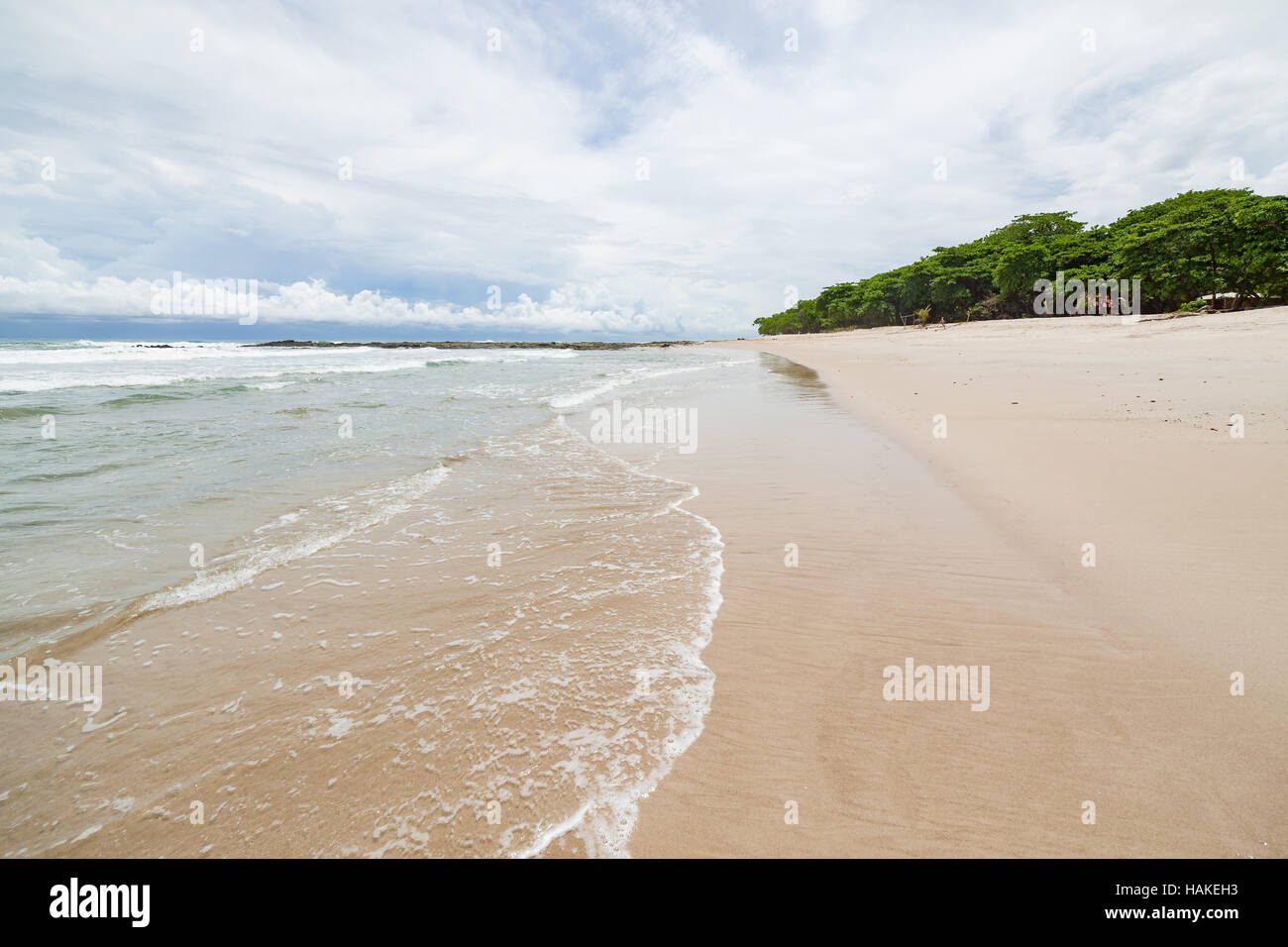 Wellen Sand Strand und Wolken Sonnentag Stockfoto