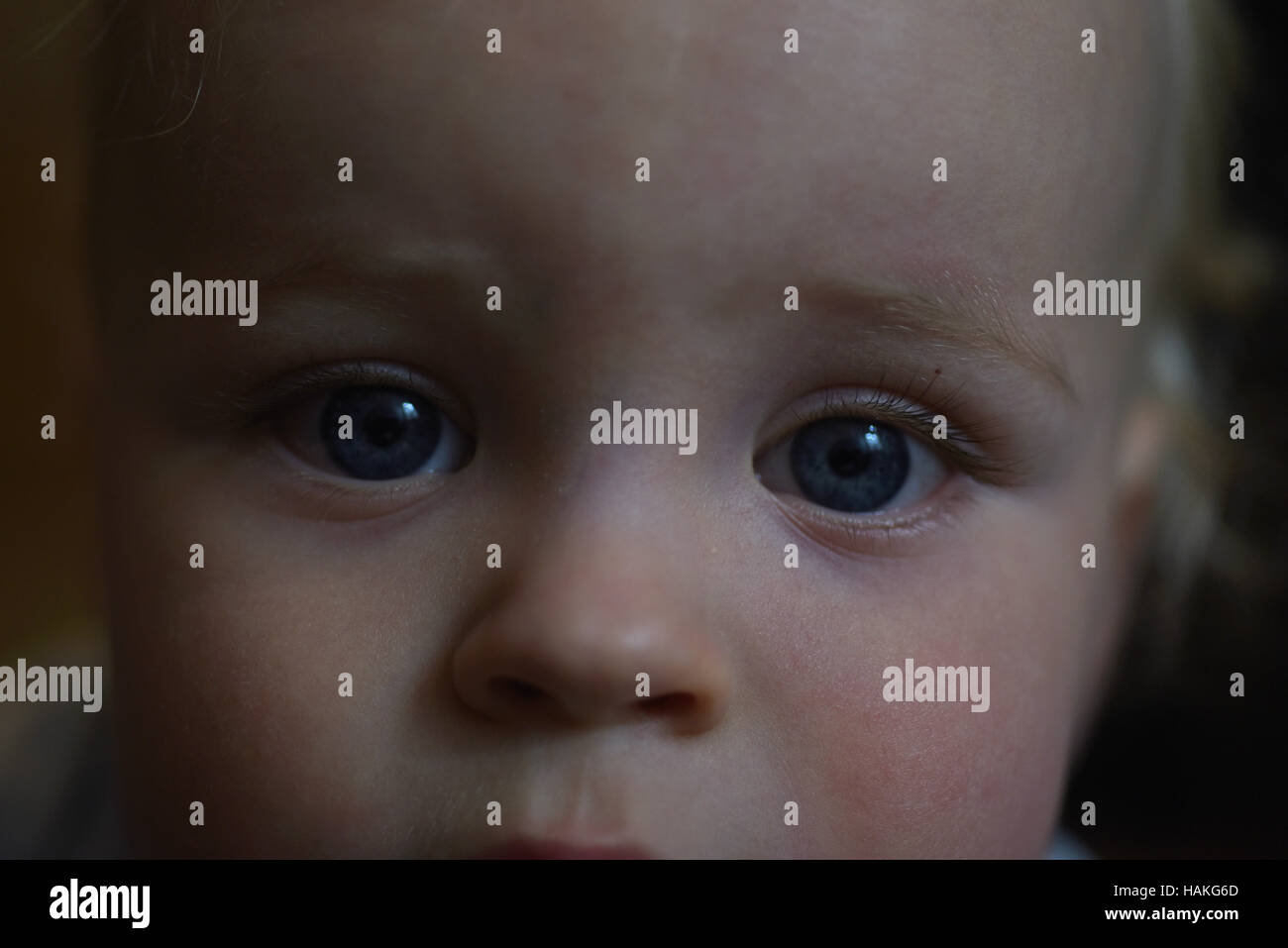 Traurige Augen Baby in der Dunkelheit. Stockfoto