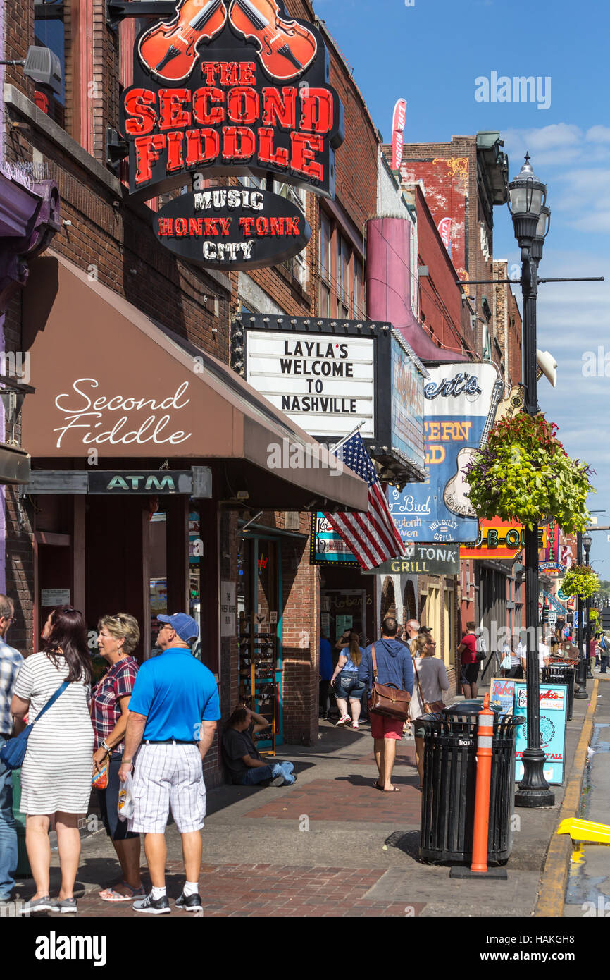Touristen halten vor Honky Tonk Bars und Geschäfte am lower Broadway in Nashville, Tennessee. Stockfoto