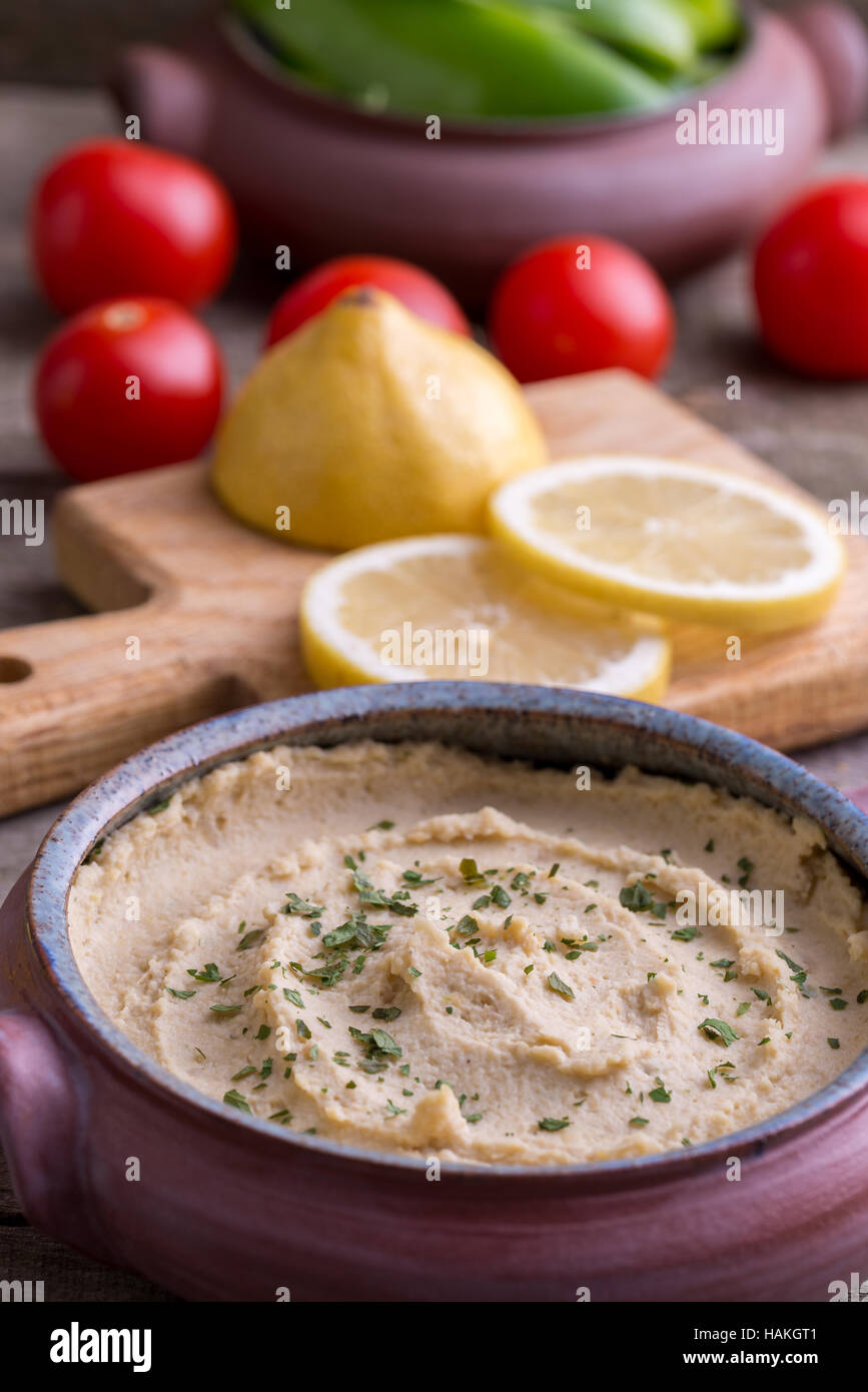 Humus in hausgemachte Schüssel mit Gemüse herum. Stockfoto