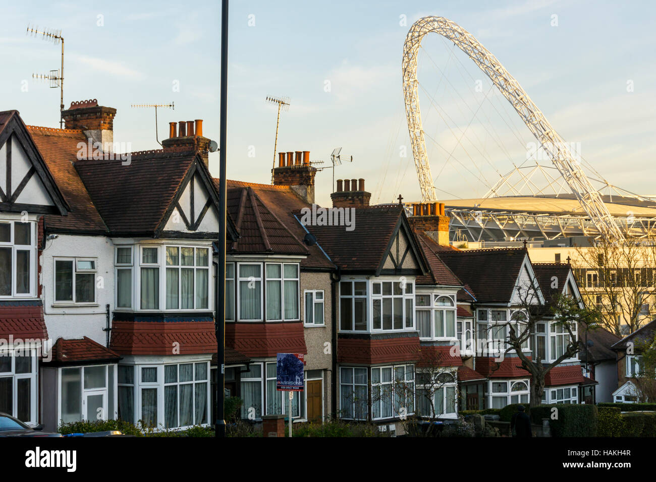 Der Bogen des Wembley-Stadion gesehen über den Dächern von s-Bahn beherbergt Wembley, London. Stockfoto