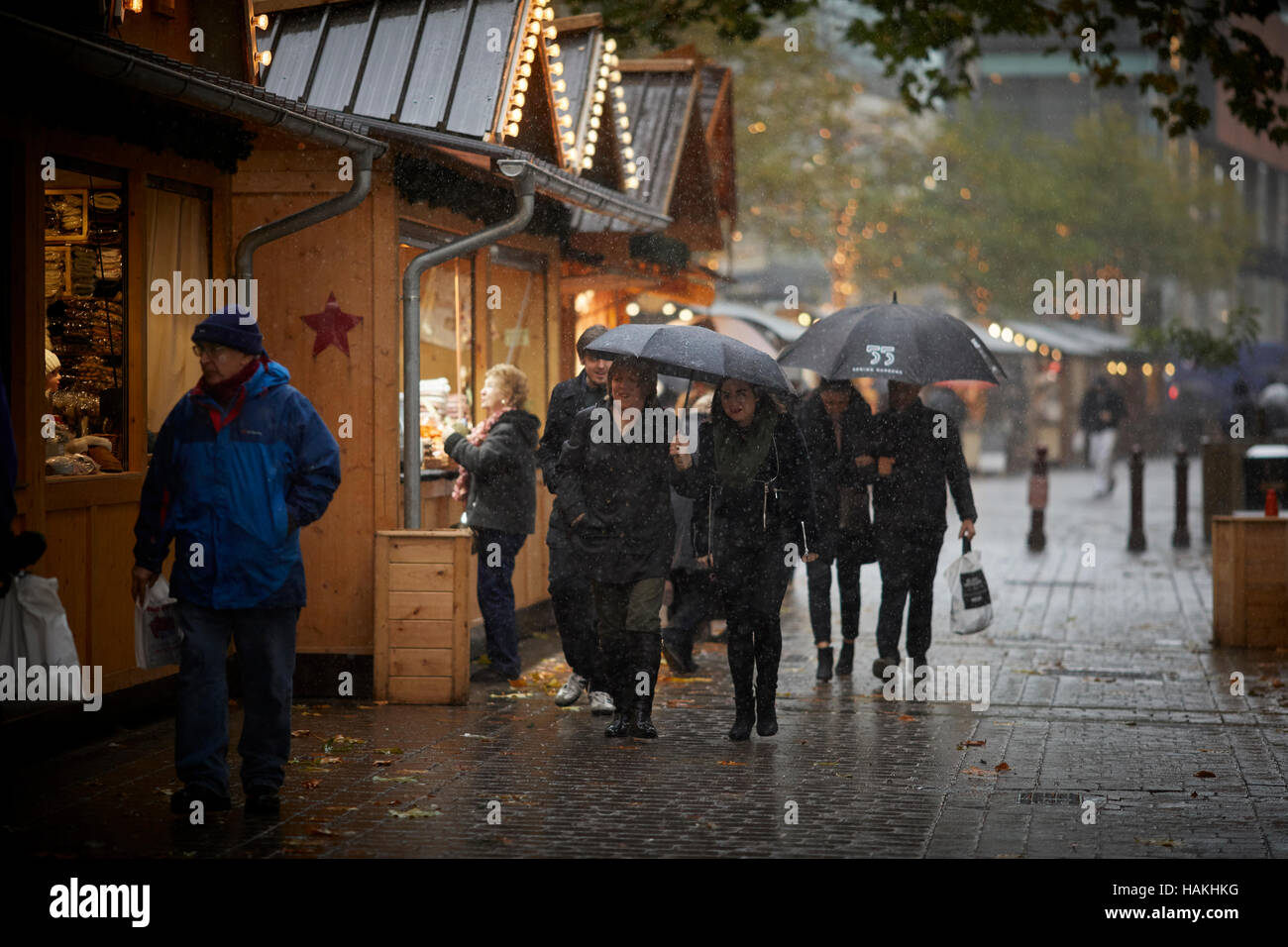 Manchester-Weihnachtsmärkte Regen feucht Regenschirm benutzte Straße Holzhütten nassen langweilig Winter Szene Markt Basar Hersteller Händler Händler unabhängigen shop Stockfoto