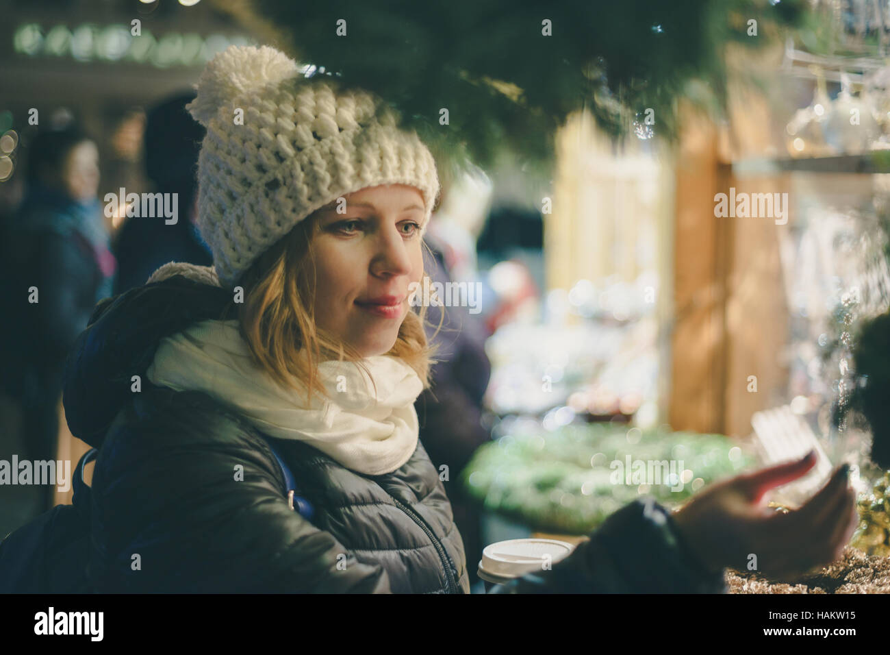 Junge hübsche Frau, die Auswahl der Geschenke am Weihnachtsmarkt. Winter-Urlaub-Souvenir-shop Stockfoto