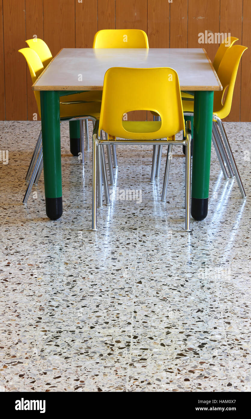 kleiner Tisch und gelbe Stühle in der Schulklasse Stockfoto