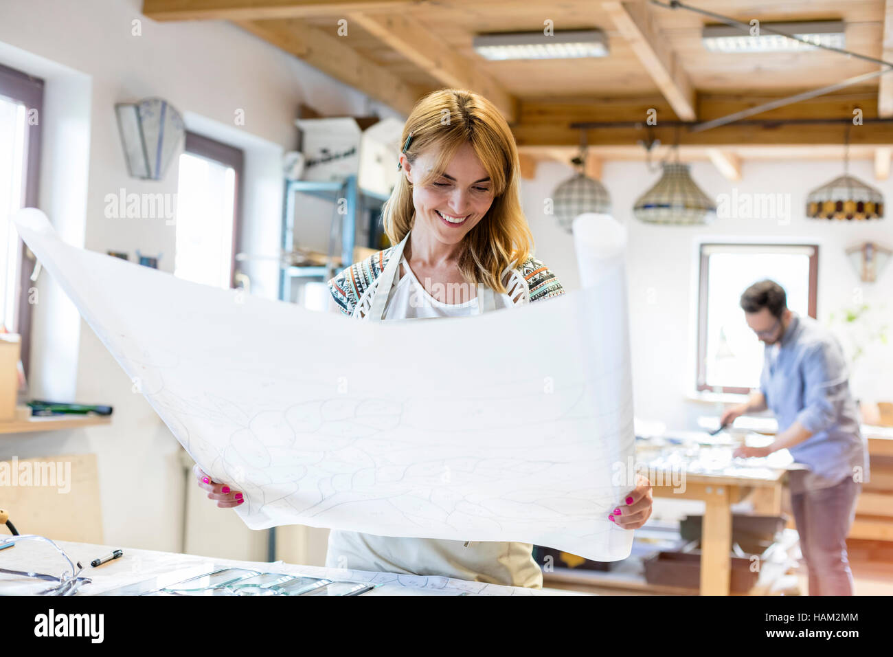 Glasmalerei-Künstler Überprüfung Blaupause Zeichnungen im studio Stockfoto