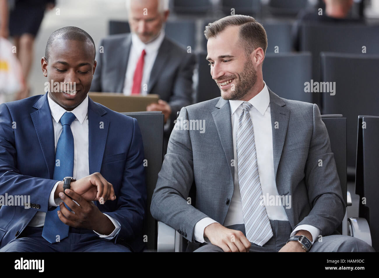 Überprüfen der Zeit auf Armbanduhr im Abflugbereich des Flughafen Geschäftsleute Stockfoto