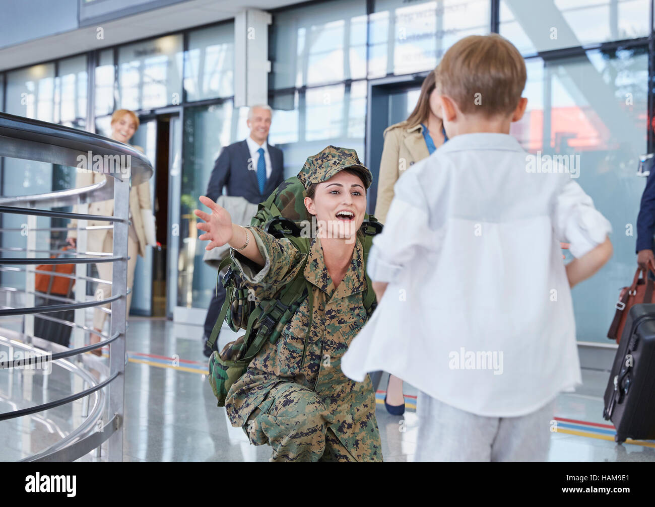 Sohn läuft Gruß Soldat Mutter am Flughafen Stockfoto