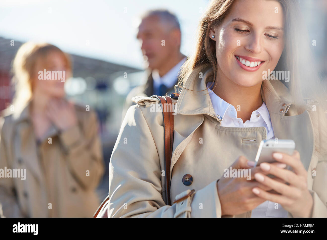 Lächelnde Geschäftsfrau SMS mit Handy Stockfoto