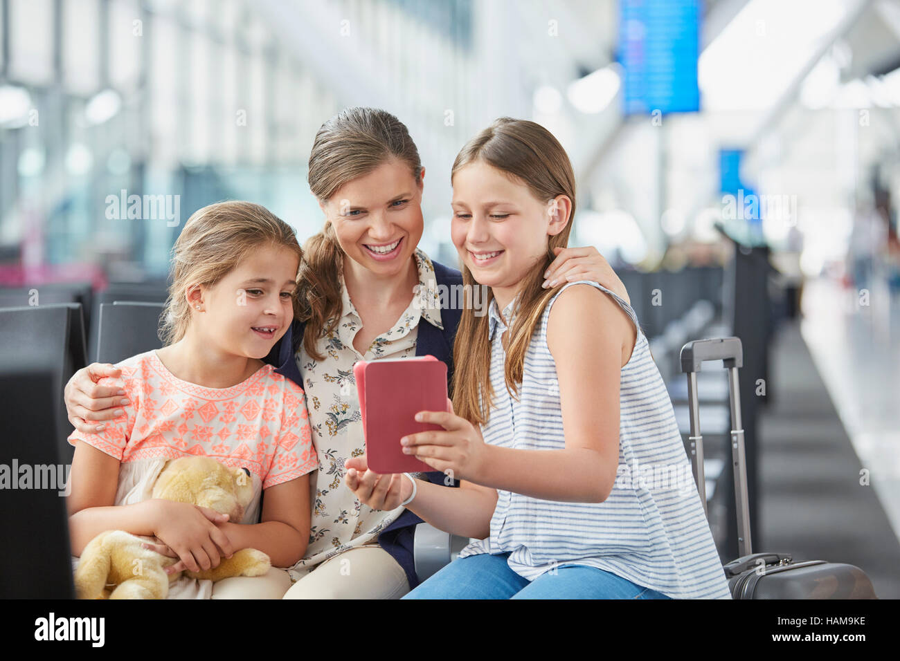 Mutter und Töchter mit digital-Tablette im Abflugbereich des Flughafen Stockfoto