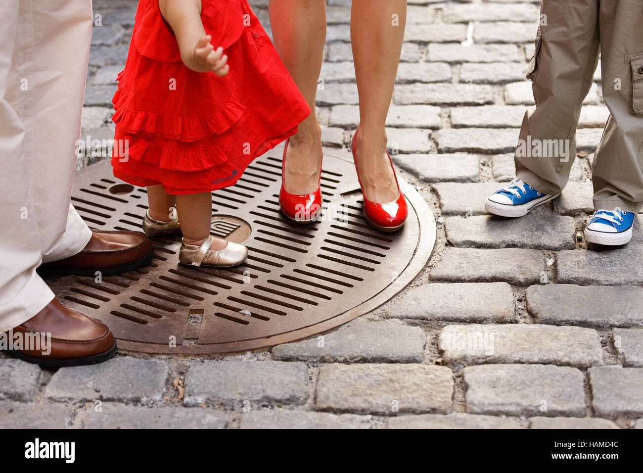 Familie - Eltern und Kinder Schuhe an Füßen stehend auf Kopfsteinpflaster Stockfoto