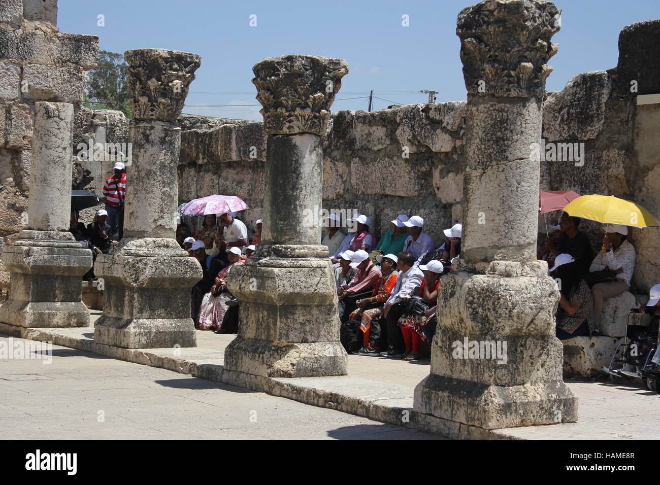 Eine Reisegruppe sitzt in den Ruinen der Synagoge, wo Jesus unterrichtet hat. Capernaum, Israel, 2016 Stockfoto