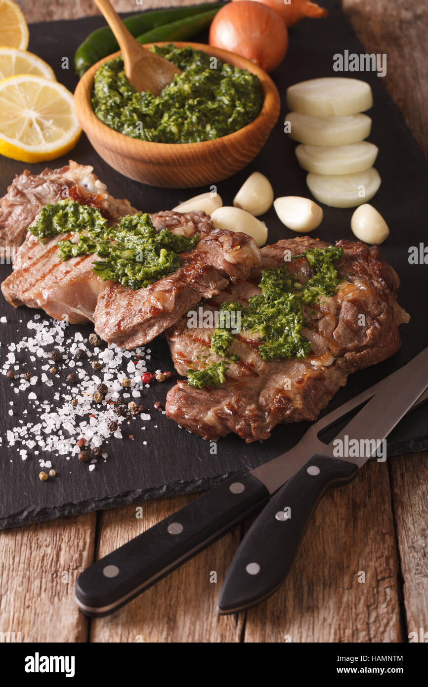 Gegrilltes Rindersteak mit würzigen Kräuter Sauce Nahaufnahme auf einer Schiefertafel Tafel. vertikale Stockfoto