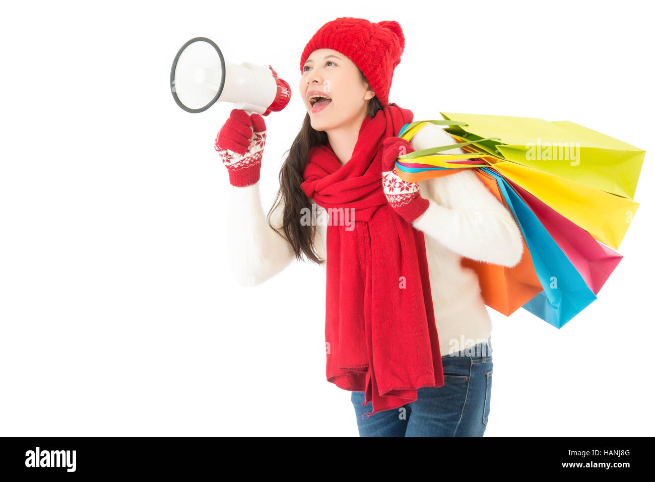 schöne asiatische Frau halten laut Megaphon Anrufs für Winterschlussverkauf mit bunten Einkaufstasche. isoliert auf weißem Hintergrund. Winter-Sale-Konzept Stockfoto