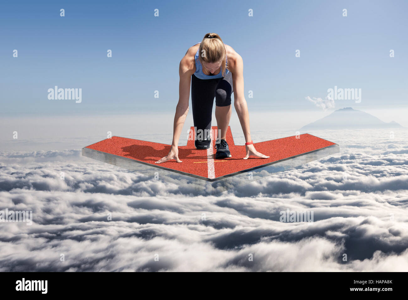 Weibliche Läufer kniet in Startposition auf einer schwimmenden Plattform Tartan Pfeil, die über den Wolken schwebt. Stockfoto