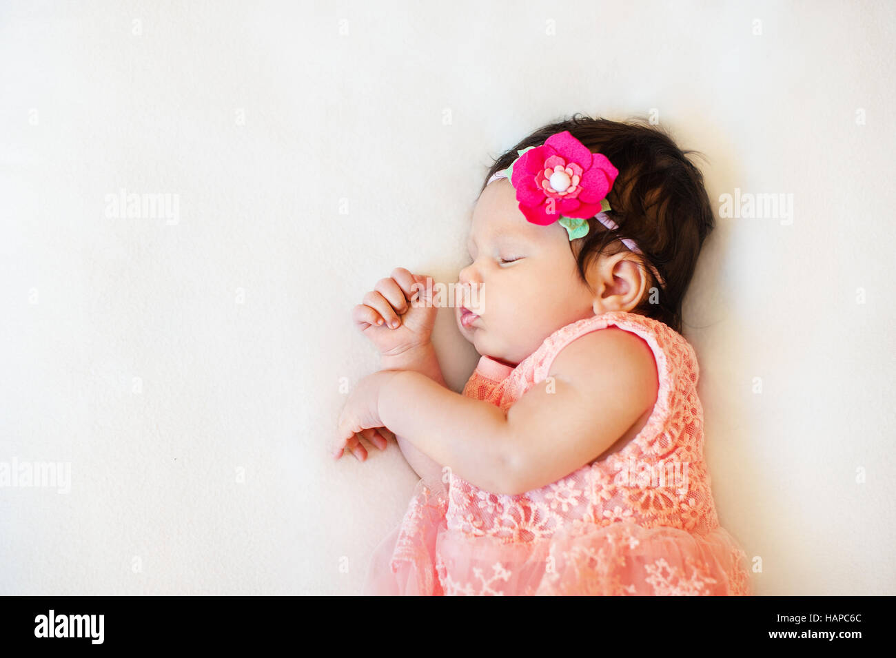 Schöne Nahaufnahmen schlafenden Baby Mädchen. Neugeborene schlafen auf einer Decke. Porträt, im Alter von 2 Monaten. tragen große, stieg Stoff Stirnband. Nahaufnahme Foto Stockfoto