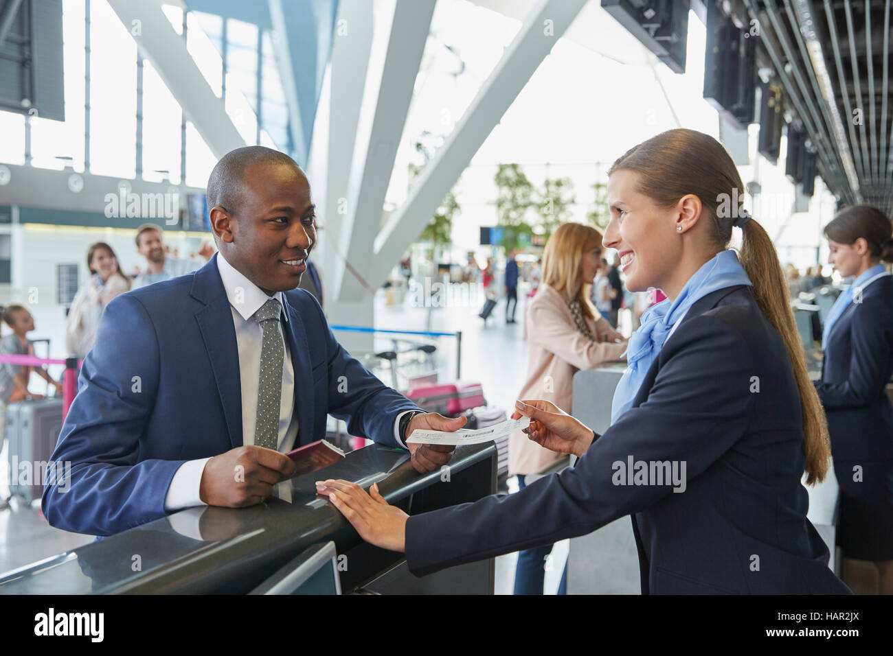 Kunden Service Vertreterin helfende Geschäftsmann am Flughafen-Check-in-Schalter Stockfoto