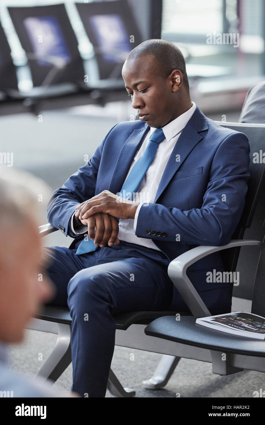 Überprüfen der Zeit auf Armbanduhr warten in der Abflughalle Flughafen Geschäftsmann Stockfoto