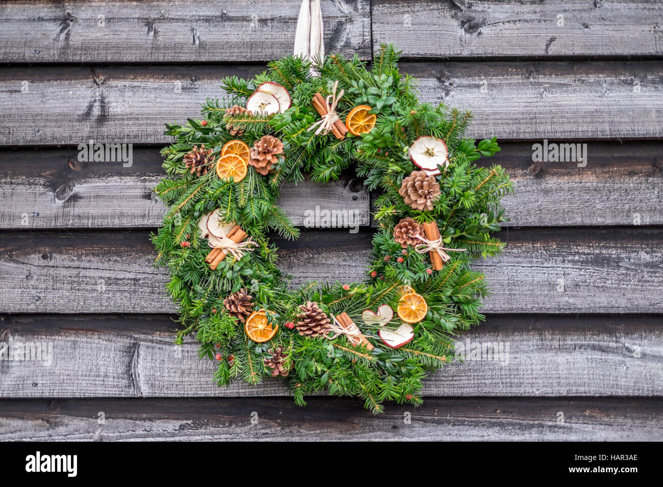 Kranz Weihnachten Holz rustikal grün Kiefer Kegel Pinecone Orangen festlichen Urlaub glücklich Dekoration Dekor Apfel-Zimt-stick Stockfoto