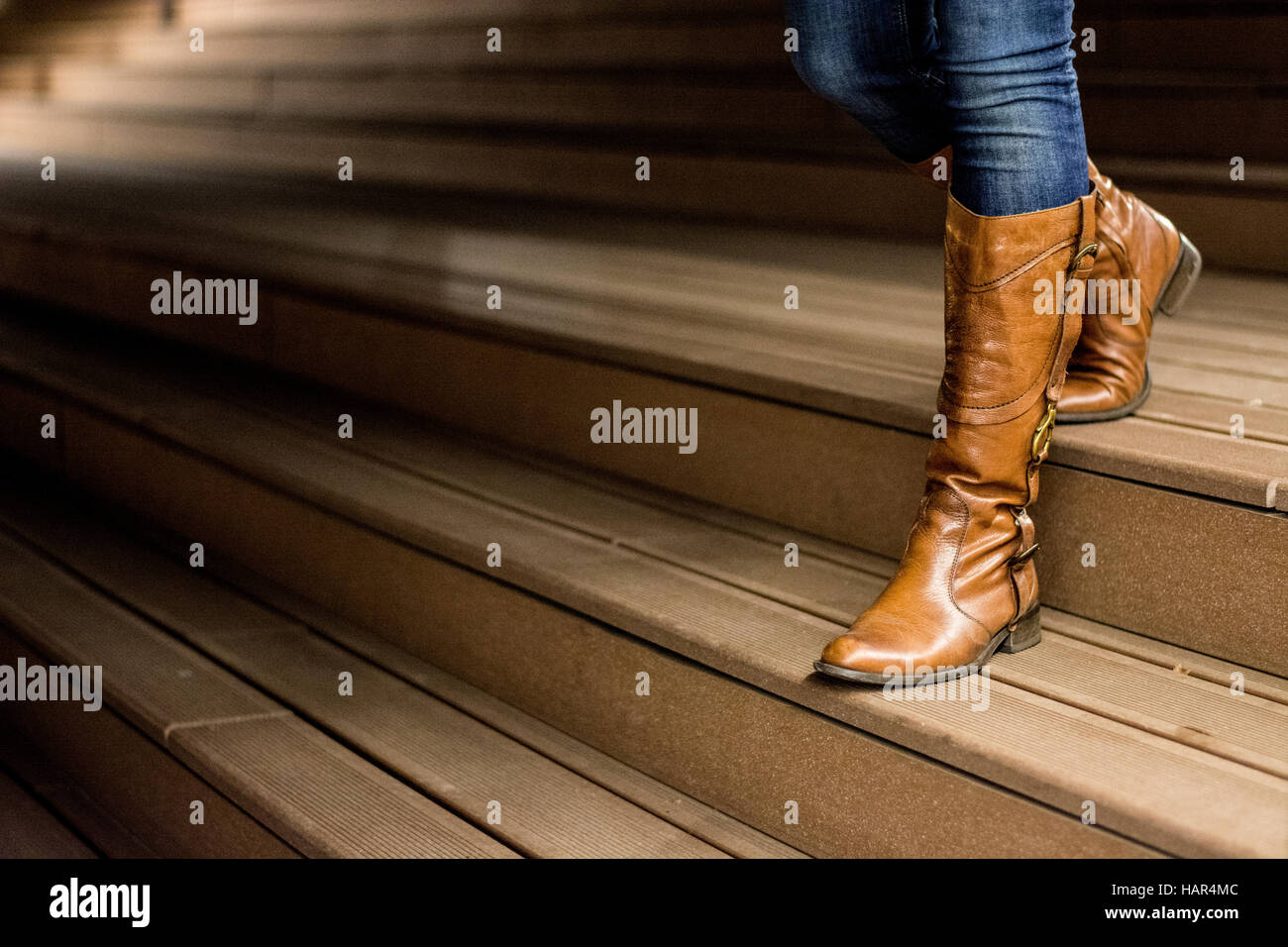 Junge Frau in Leder Stiefel stehen auf Holztreppen in der Nacht Stockfoto