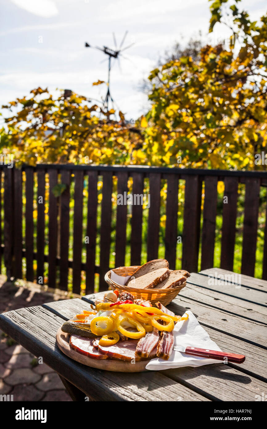 Brettljause, traditionellen hölzernen Platte mit Aufschnitt nur mit selbst zubereiteten Speisen auf Terrasse im Weinberg auf westlichen Steiermark Wein route Stockfoto