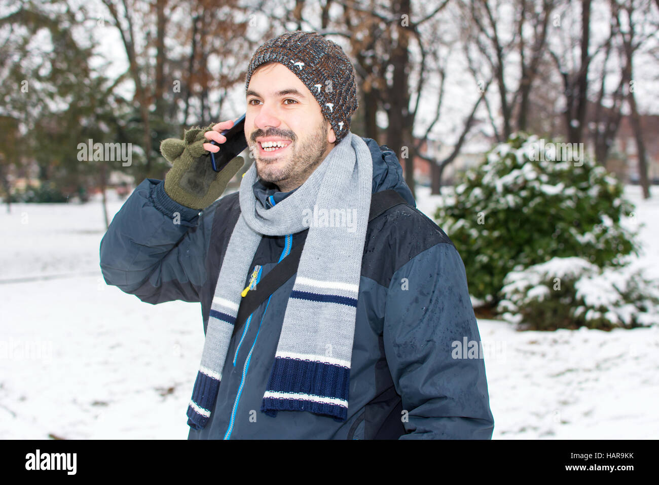 Barde Jüngling mit Handy im winter Stockfoto