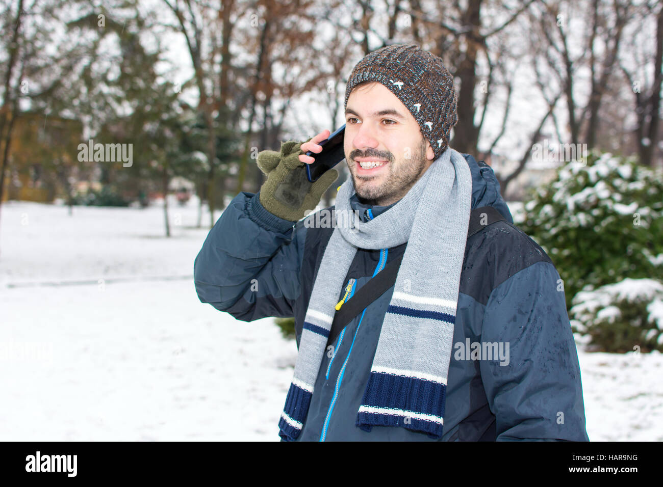 Barde Jüngling mit Handy im winter Stockfoto