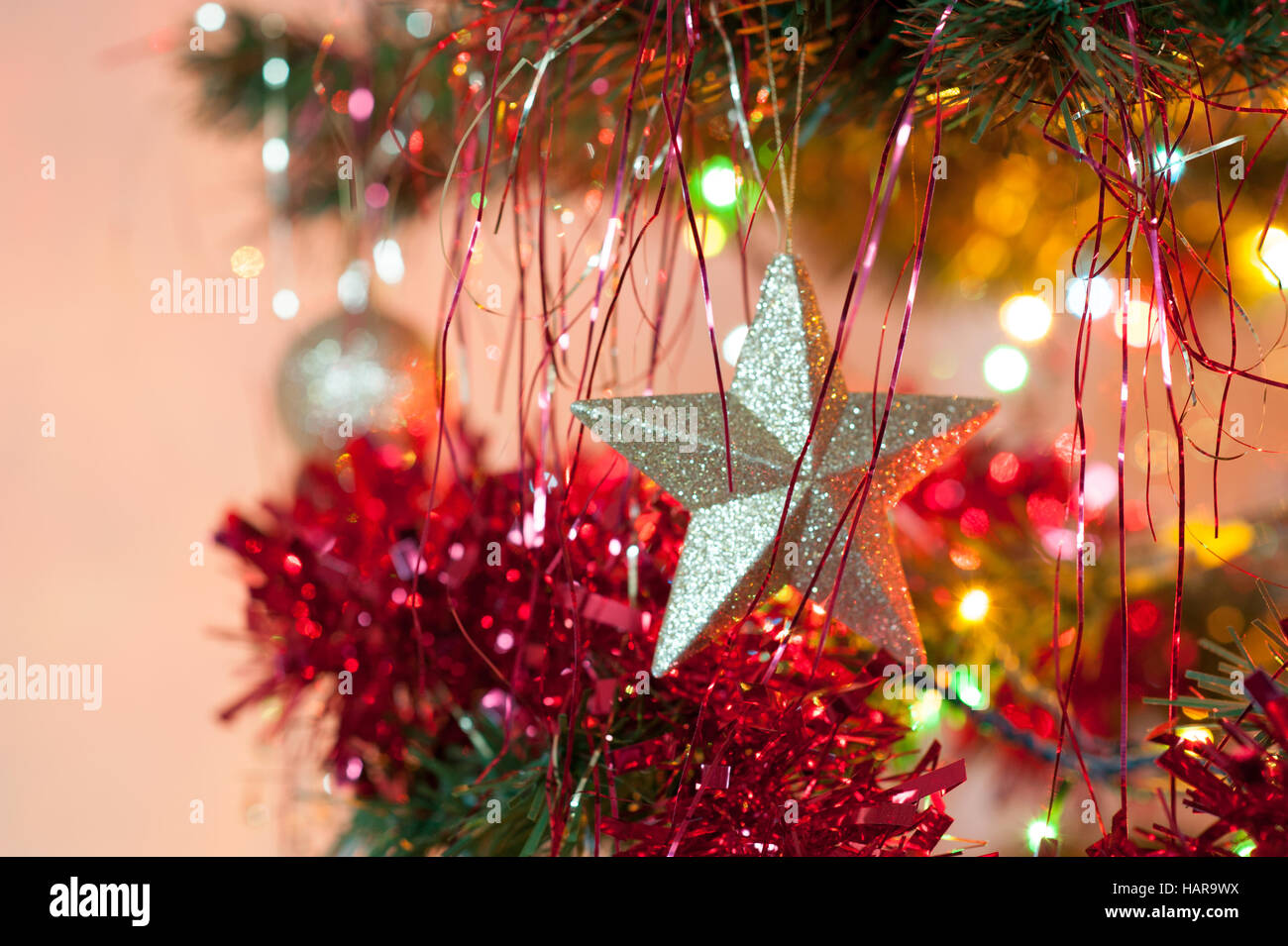 Weihnachtsstern auf gold von Baumschmuck mit Lametta Stockfoto