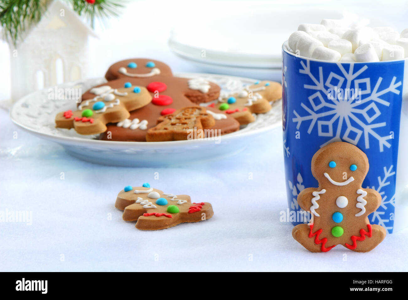 Niedliche kleine Lebkuchenmänner mit Schneeflocke Tasse heiße Schokolade verziert und Mini Marshmallows für Weihnachten zu behandeln Stockfoto