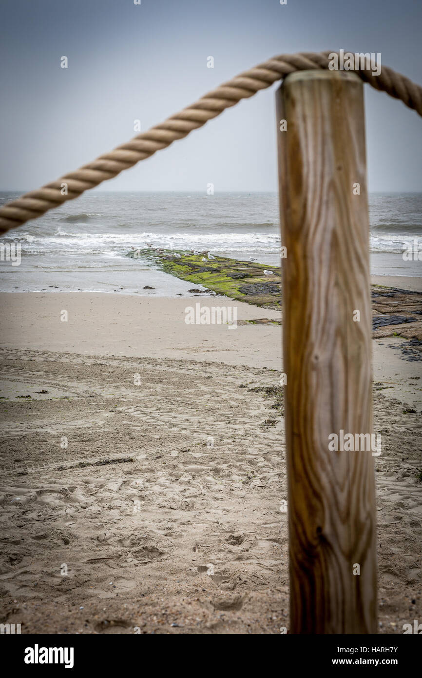Strand-Post mit Seil Geländer oben und Strand im Hintergrund, Insel Norderney, Deutschland, Europa. Stockfoto