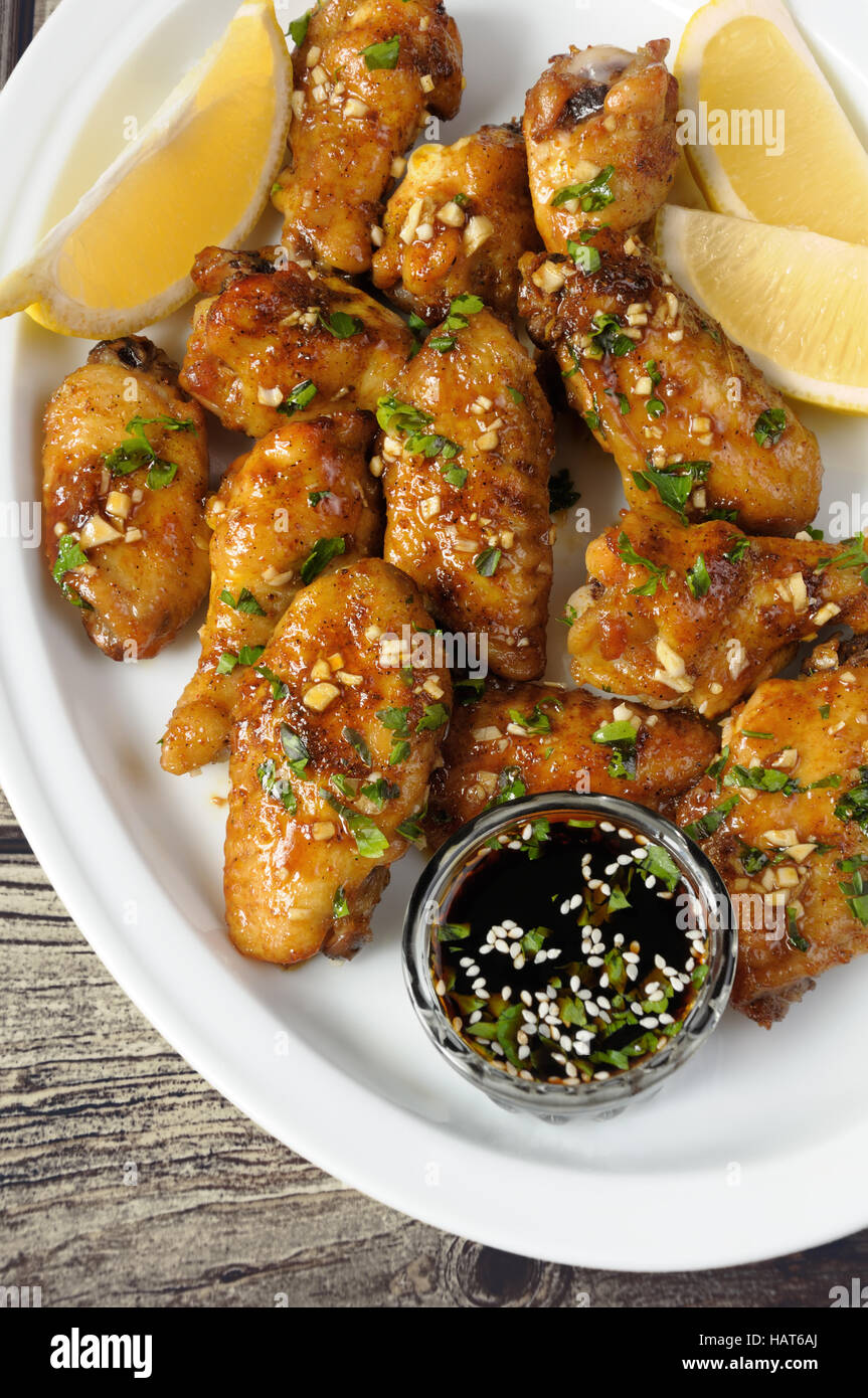 Gebratene Hähnchenflügel in Ingwer Knoblauch Marinade mit Kräutern Stockfoto