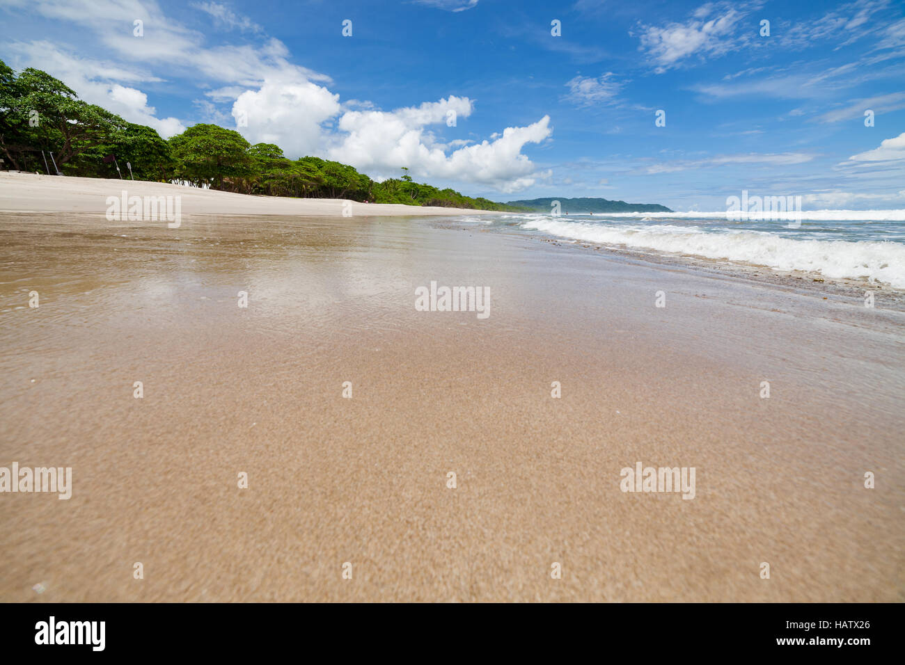 Wellen Sand Strand und Wolken Sonnentag Stockfoto