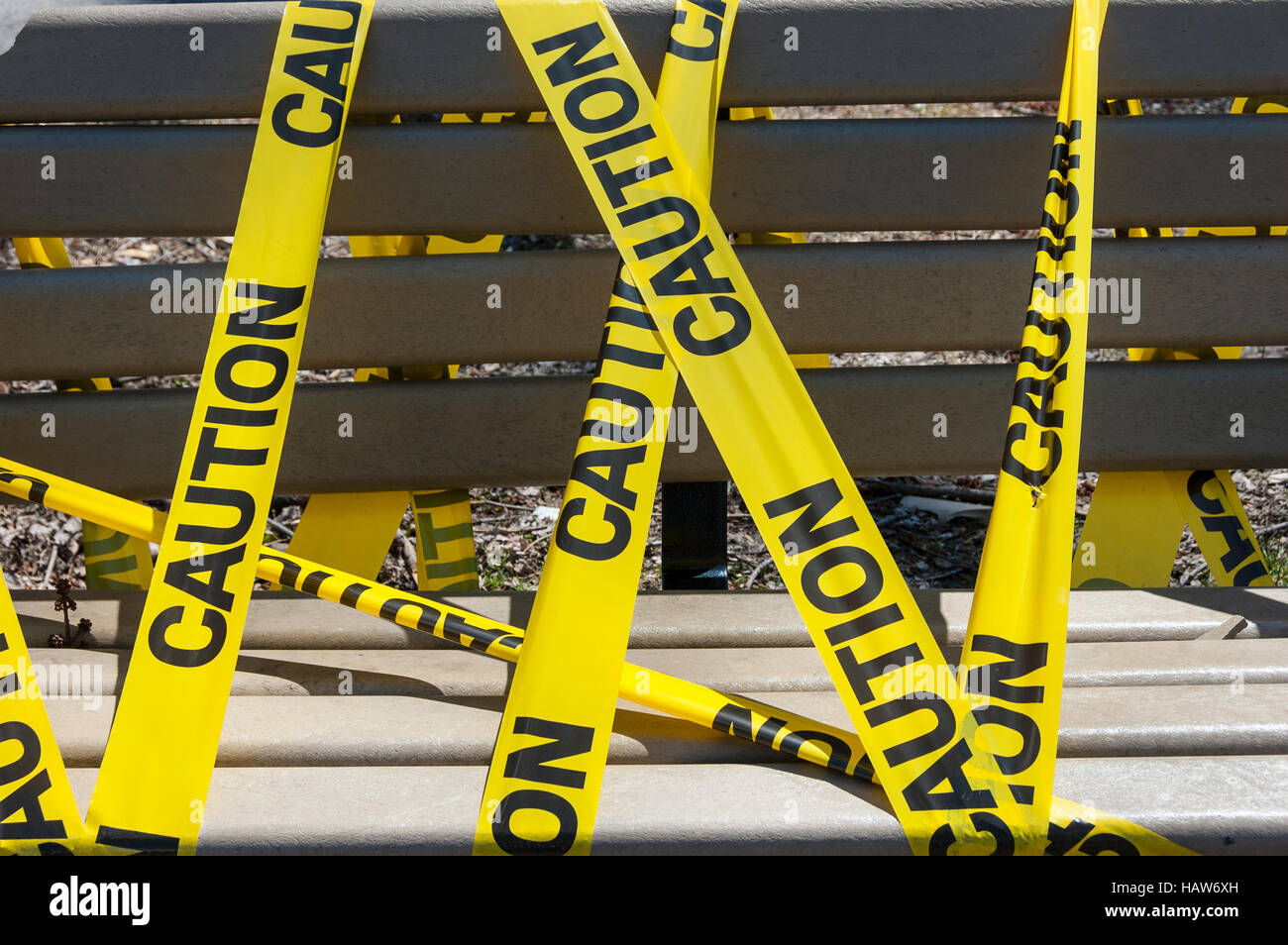 Eine Parkbank mit gelben Absperrband eingewickelt. Stockfoto