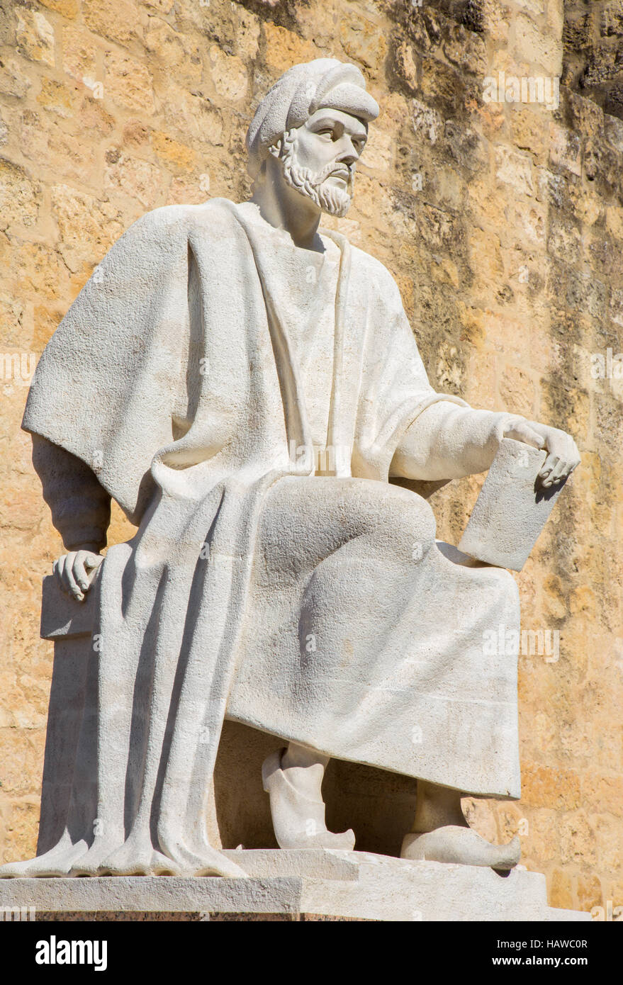 Córdoba, Spanien – 25. Mai 2015: Die Statue des mittelalterlichen arabischen Philosophen Averroes von Pablo Yusti Conejo (1967) und der mittelalterlichen Stadtmauer. Stockfoto