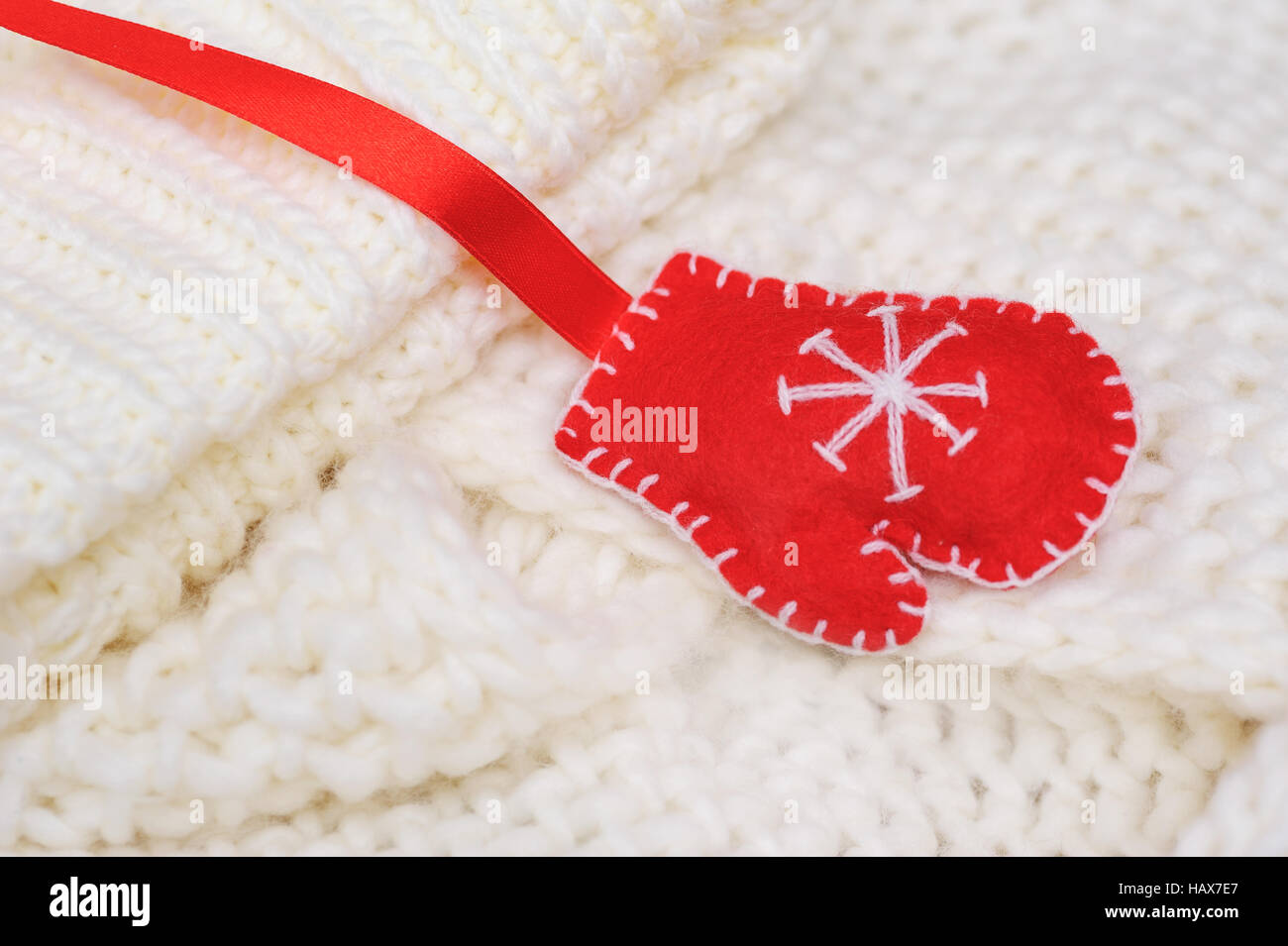 weiße Textur gestrickte Schal und Mütze mit einem roten Handschuh Stockfoto