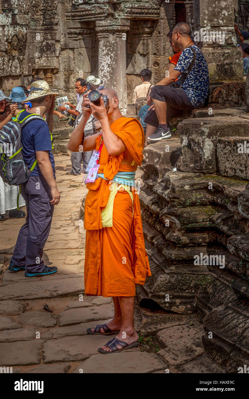 Ein buddhistischer Mönch im Urlaub bei Angkor Thom nimmt Fotos der Ruinen in Siem Reap, Kambodscha. Stockfoto