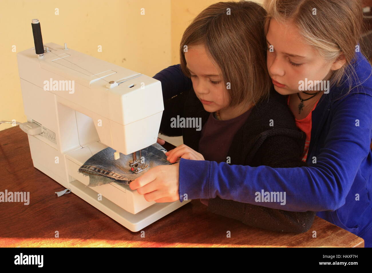 Zwei Mädchen lernen zu nähen Stockfoto