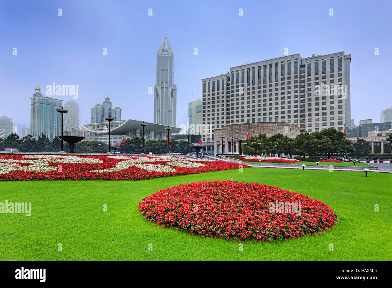 Menschen Quadratmeter Rasen und Blumenschmuck vor modernen Gebäuden. Stadt Shanghai, China. Stockfoto