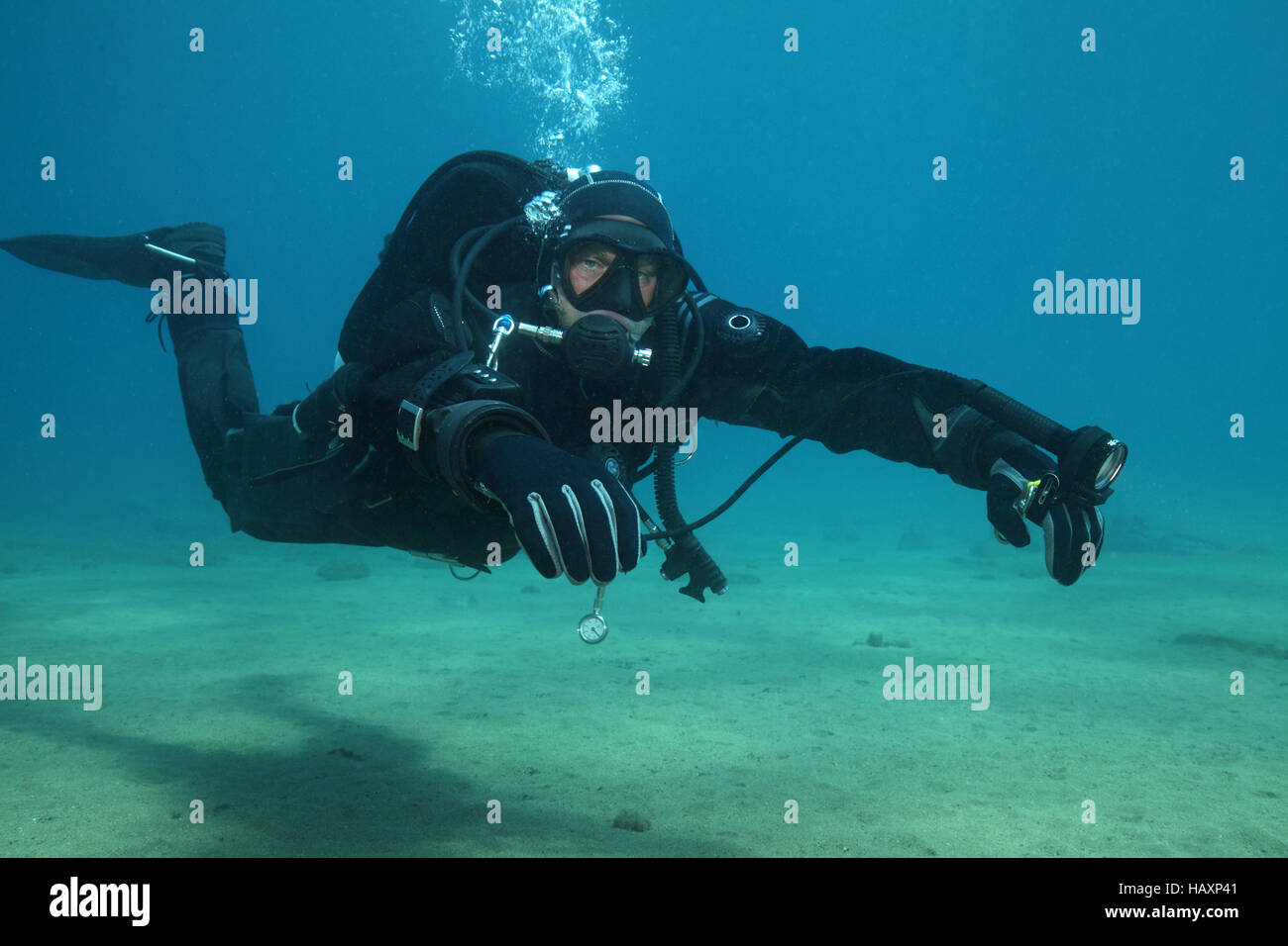 Professionelle Taucher mit schwarzen Trockenanzug Tauchen unter Wasser im Meer Stockfoto