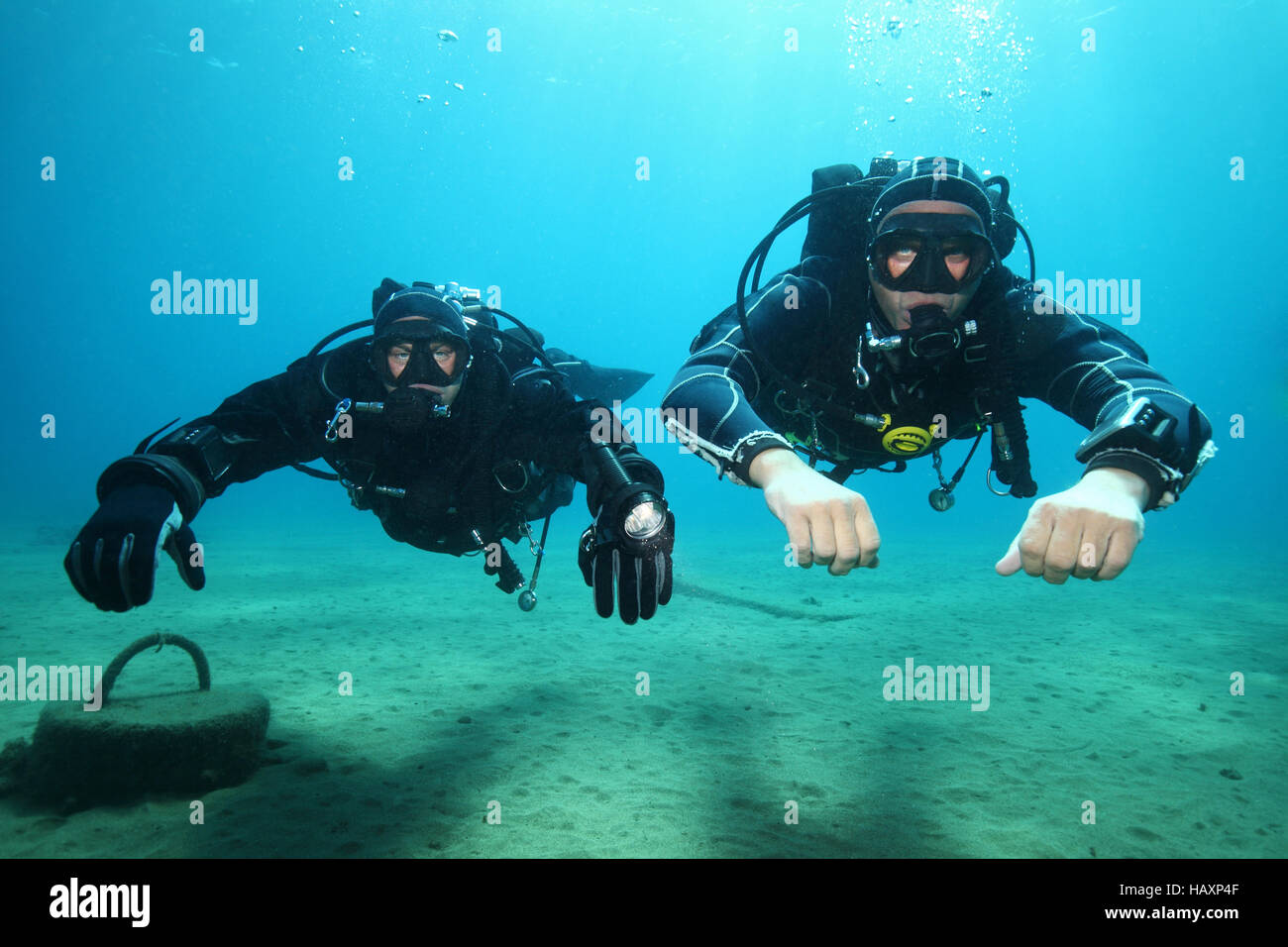 Professionelle Taucher mit schwarzen Trockenanzug Tauchen unter Wasser im Meer Stockfoto