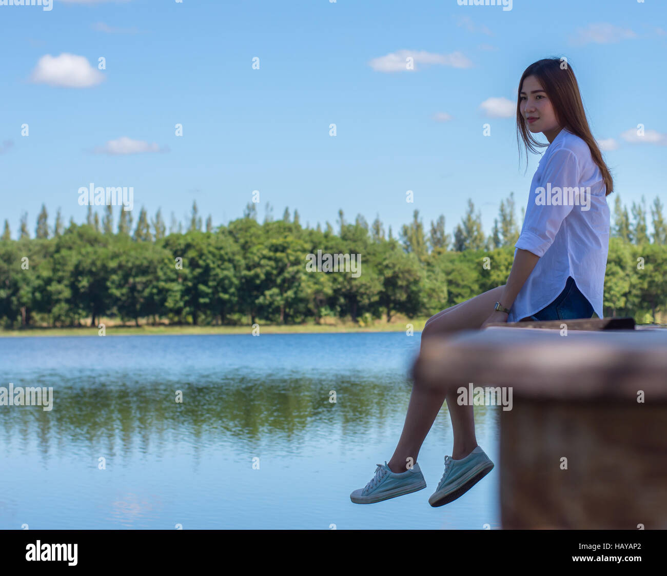Asiatische Frau Natur auf einer Bank am Pool genießen. Stockfoto