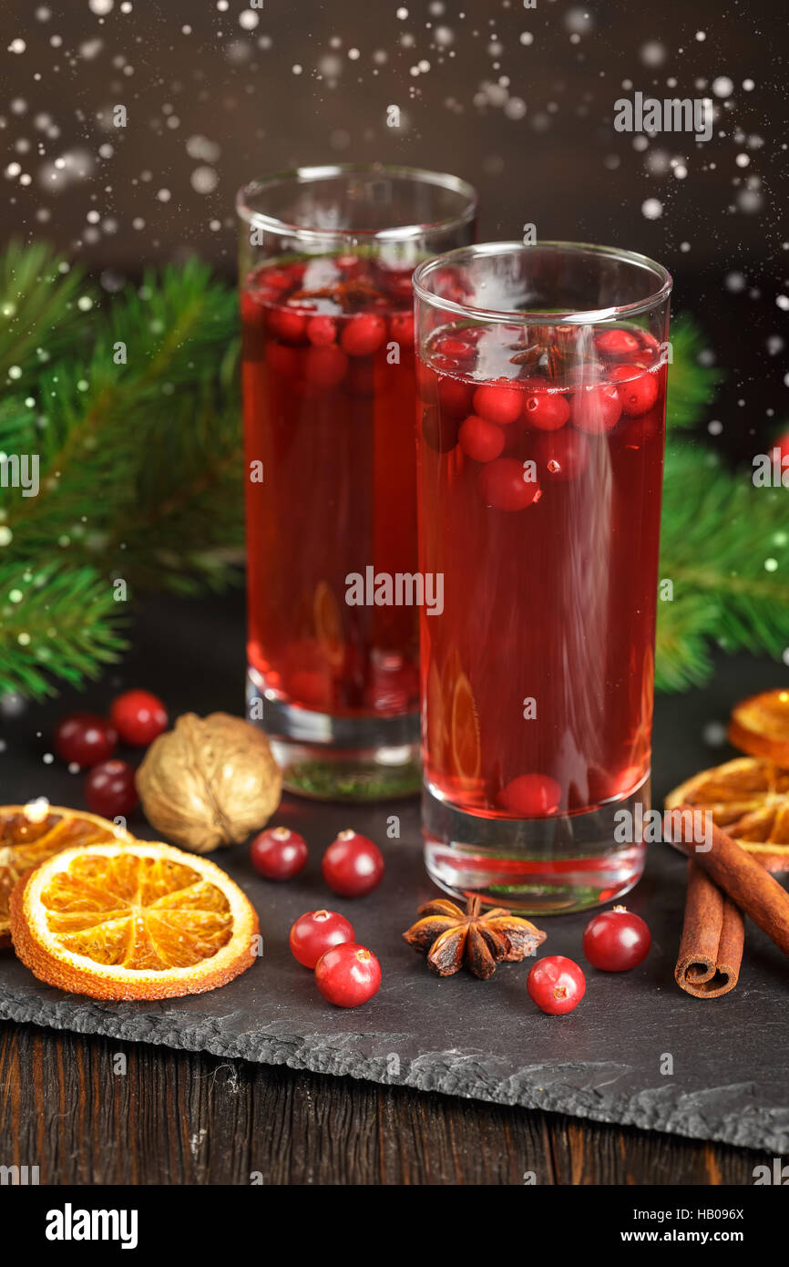 Zwei Gläser mit einer erfrischenden Cranberry Cocktaildecorated mit Tannenzweigen, trockenen Orangenscheiben, Zimtstangen und Anis Sterne Stockfoto