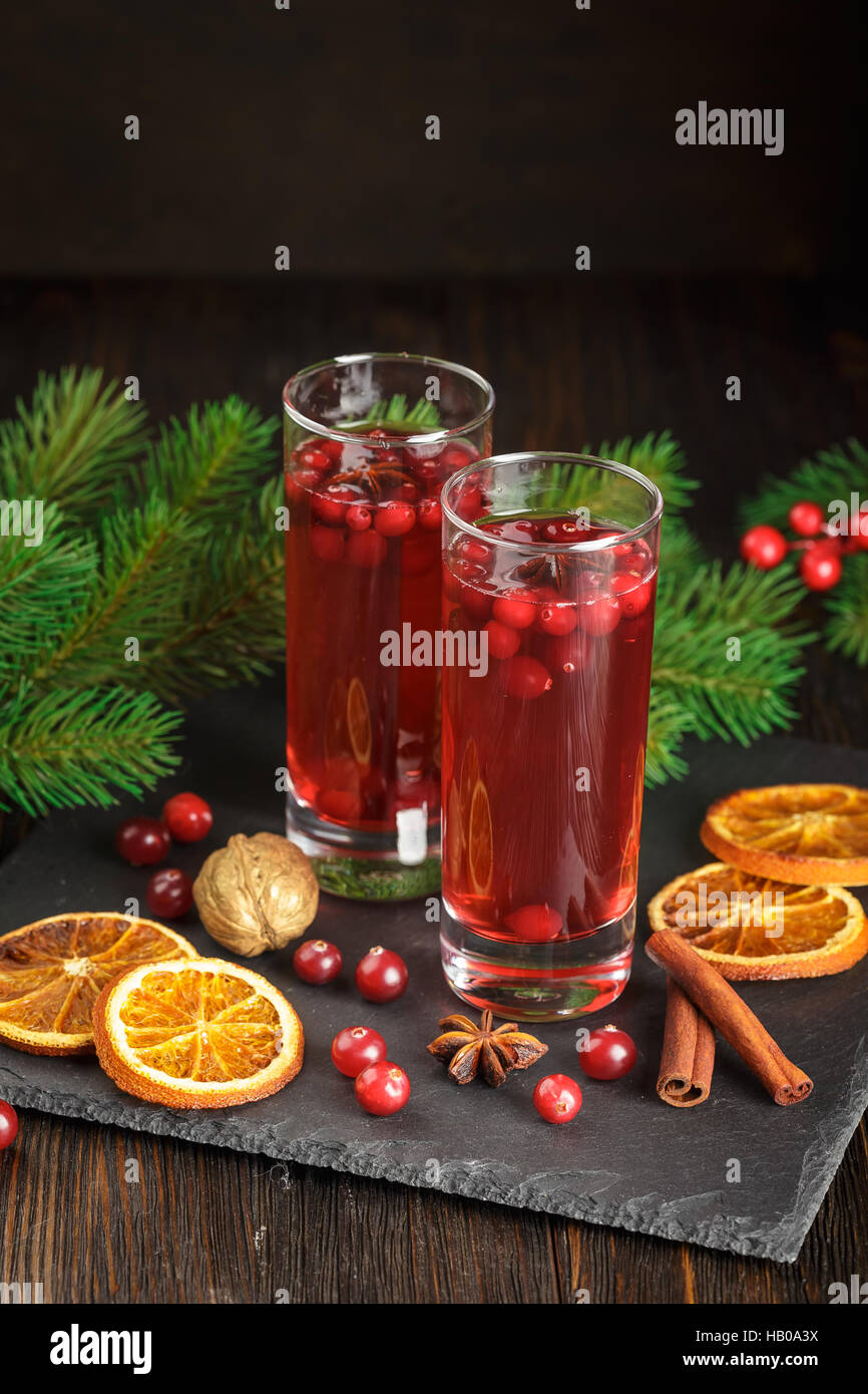 Weihnachten-Cranberry cocktail verziert mit Tannenzweigen, trockenen Orangenscheiben, Zimtstangen und Anis Sterne Stockfoto